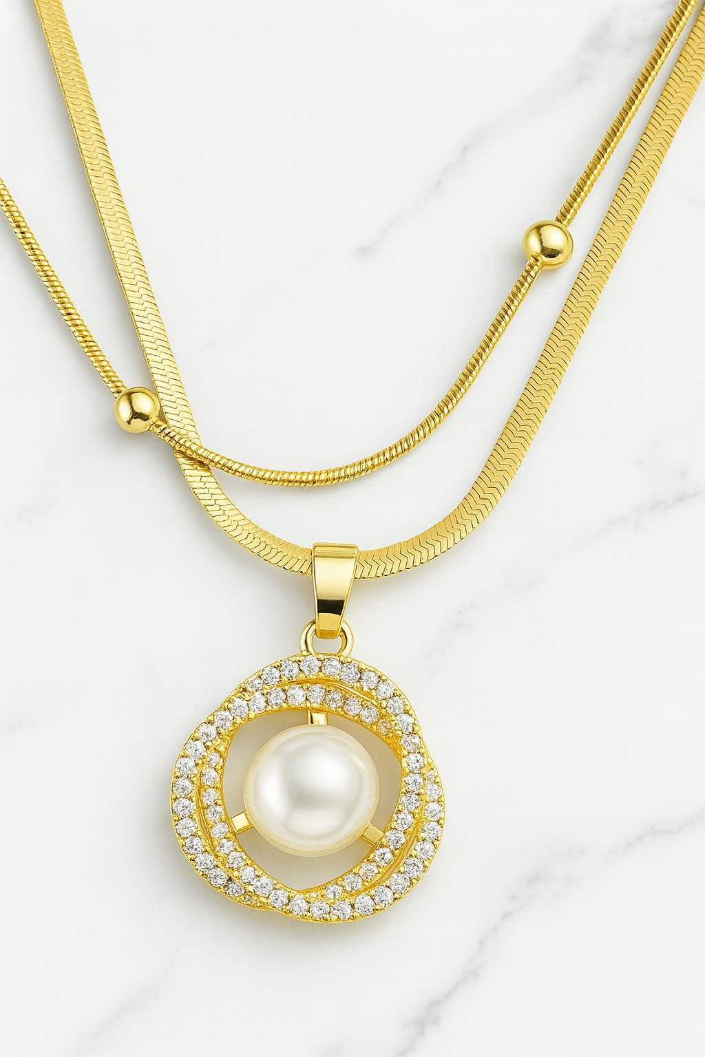 Gold-plated double-layer necklace with pearl and CZ diamond pendant on marble background - perfect for festive or party wear