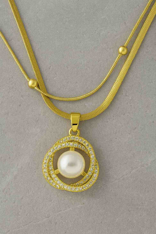 Gold-plated double-layer necklace with pearl and CZ diamond pendant on marble background - perfect for festive or party wear