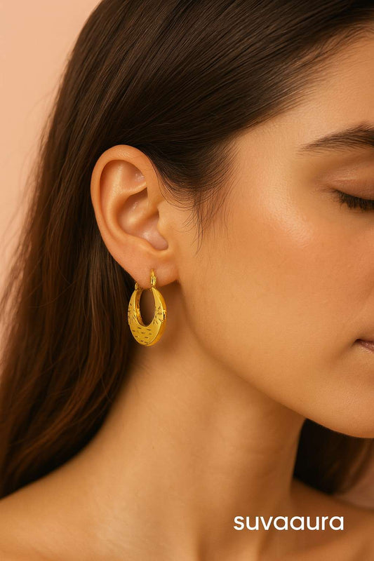 Gold-plated moon-shaped hoop earrings with ethnic floral texture on peach background – festive jewellery by Suvaaura