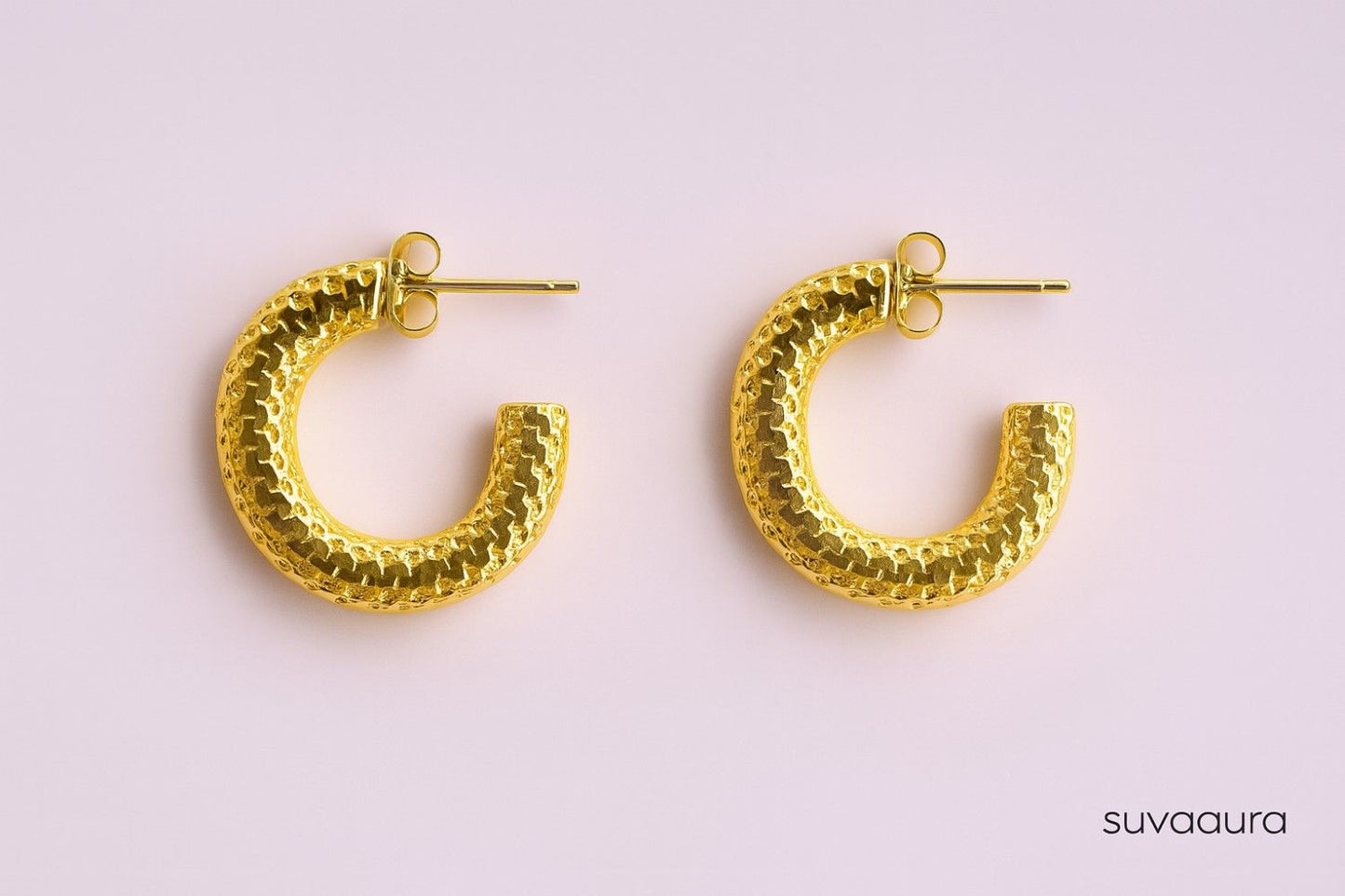 Textured gold-plated C-shaped hoop earrings on pink background – everyday style by Suvaaura