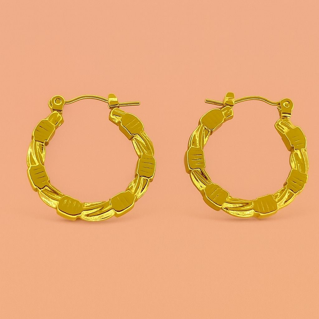 Gold hoop earrings with beaded and twisted texture on peach background – Suvaaura chunky hoop design