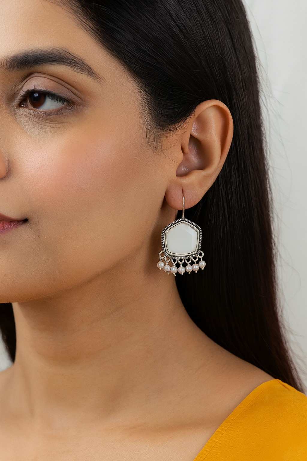 "Model wearing antique silver white stone earrings with pearl bead detailing"