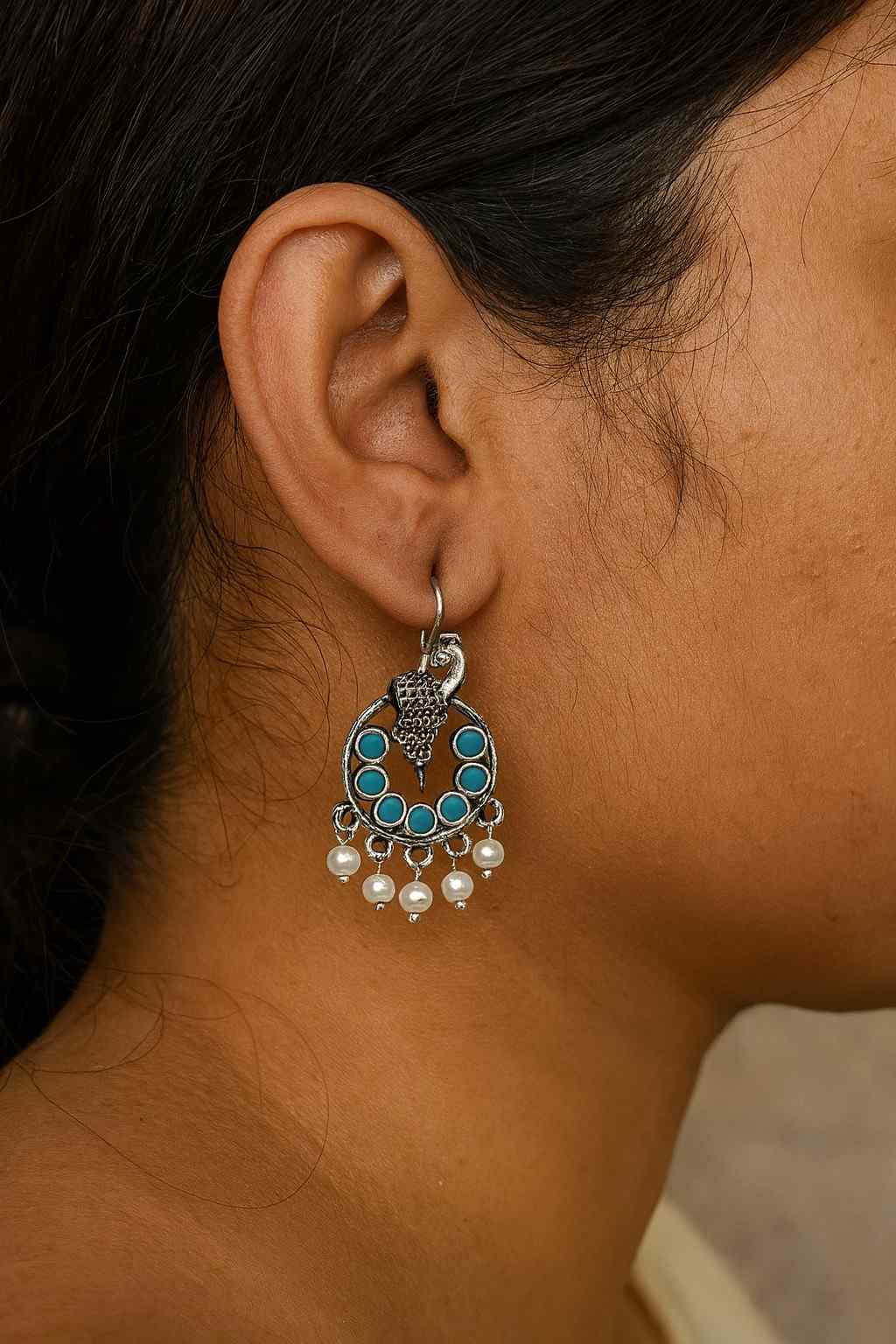 Antique silver peacock earrings with turquoise beads and pearl drops – worn on ear