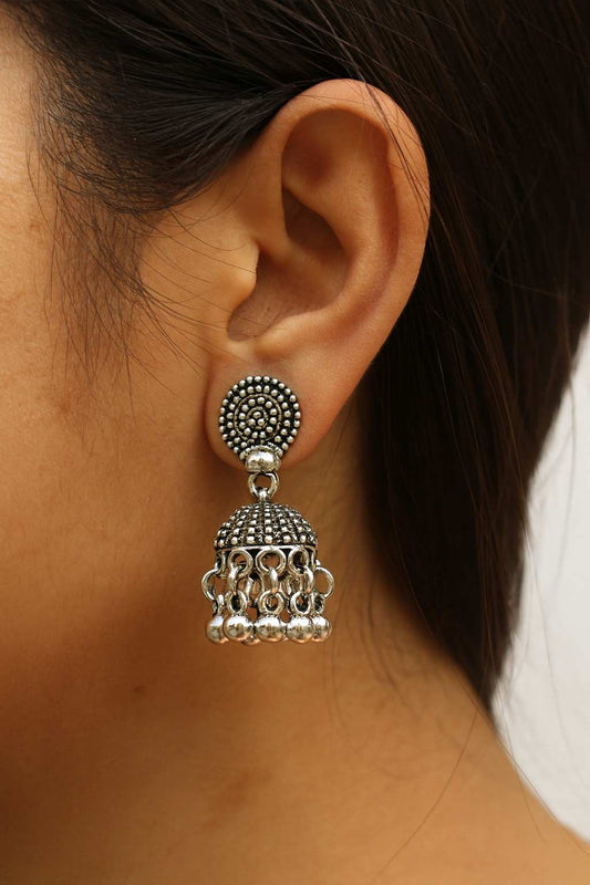 Woman wearing oxidized silver-tone dome jhumka earrings with beaded detailing