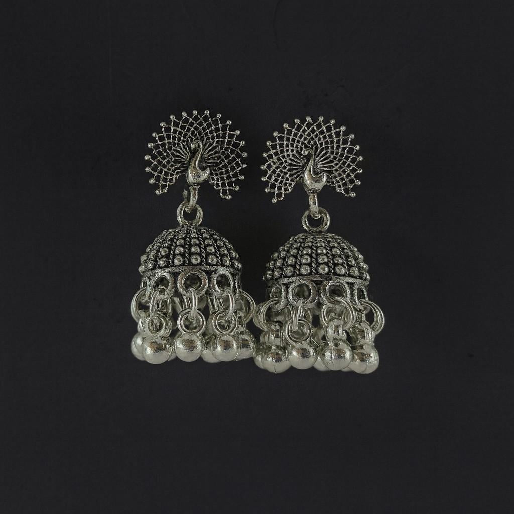 Oxidized peacock design silver-tone jhumka earrings with hanging beads on plain background
