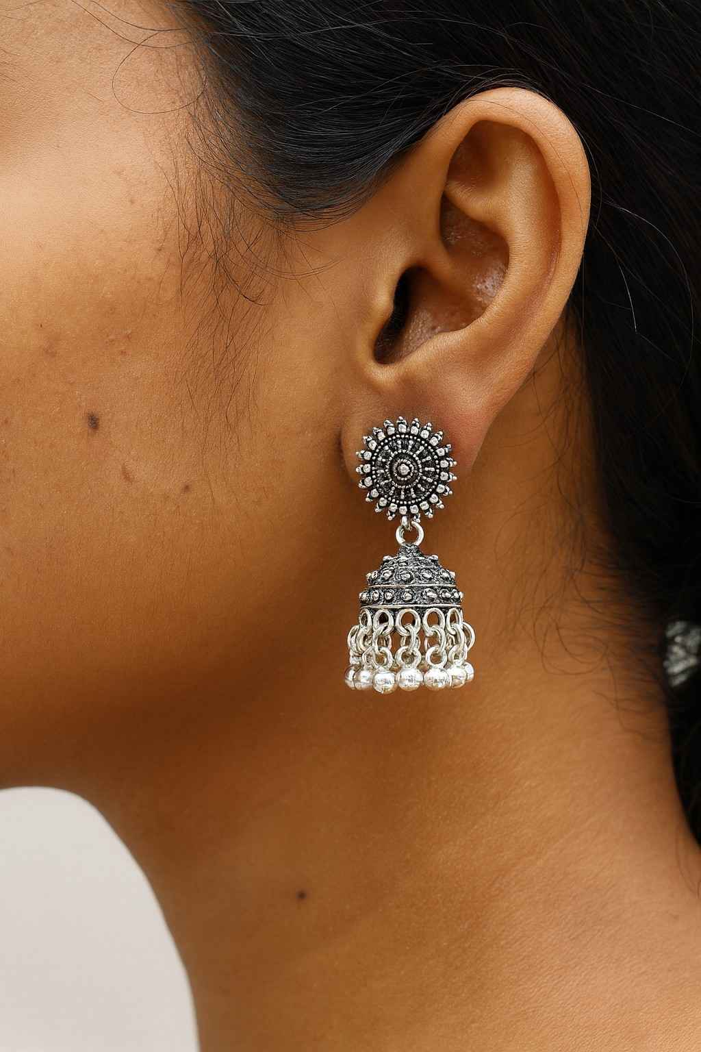 Antique oxidized silver-tone circular stud jhumka earrings worn by model