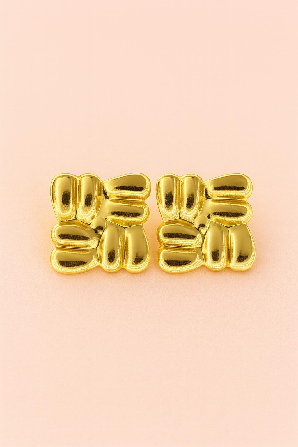 "Glossy gold imitation stud earrings on peach background – Suvaaura"