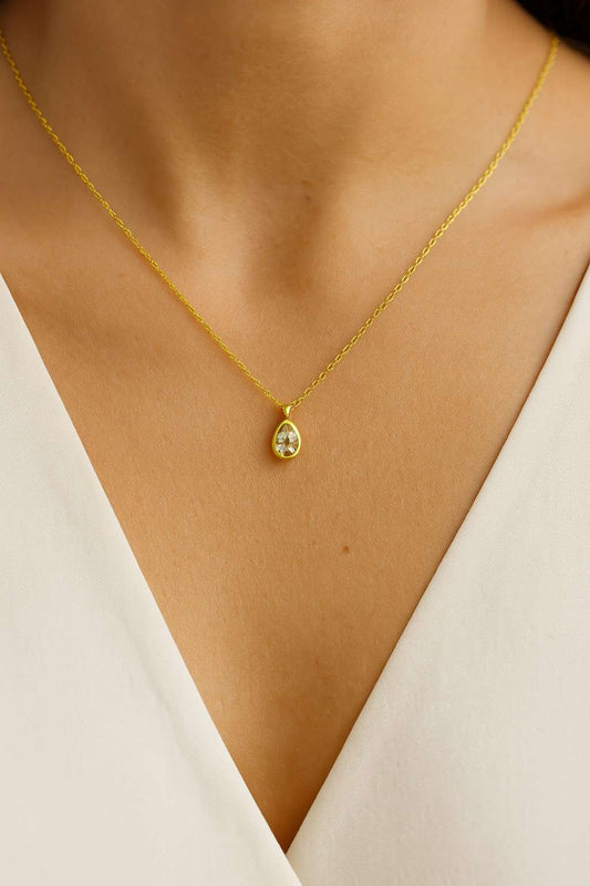 "Model wearing teardrop crystal gold-tone pendant necklace – Suvaaura"