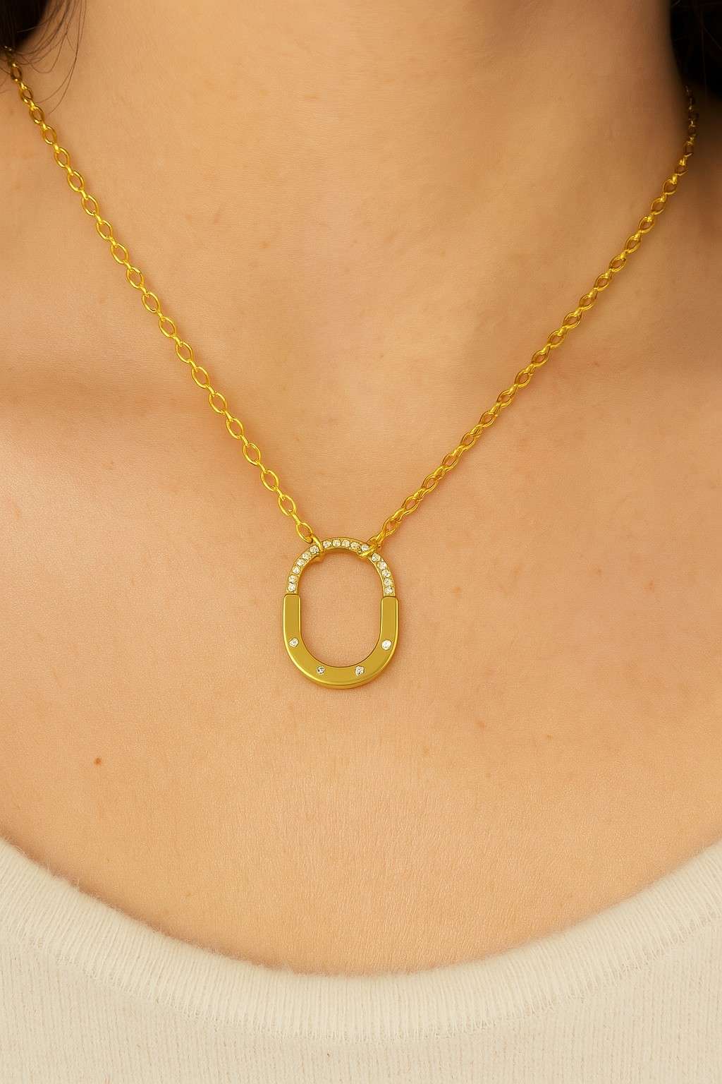 Close-up of gold-tone oval pendant on gold chain for women’s jewellery