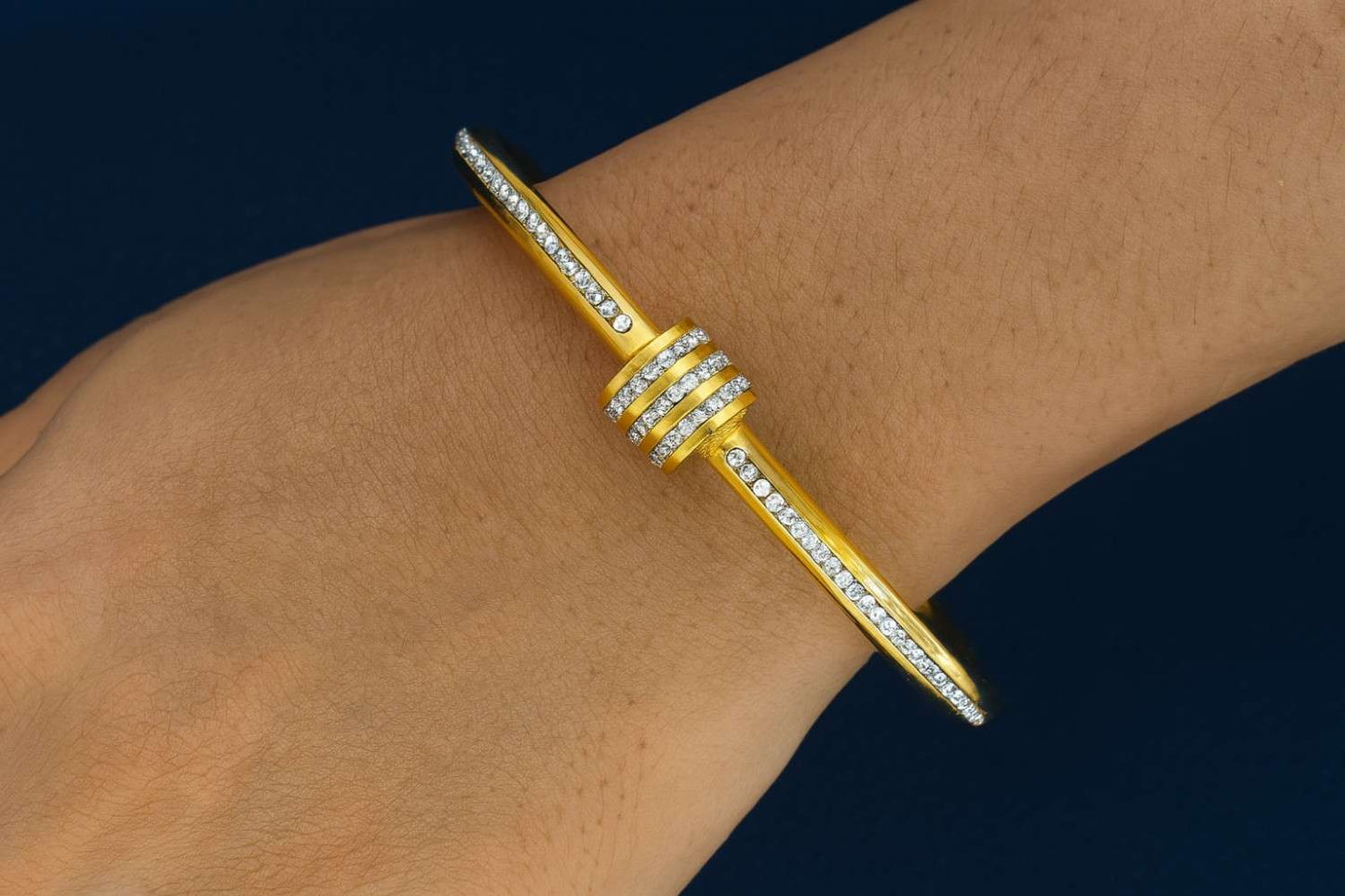 Elegant gold-tone bracelet worn on wrist with sparkling stones