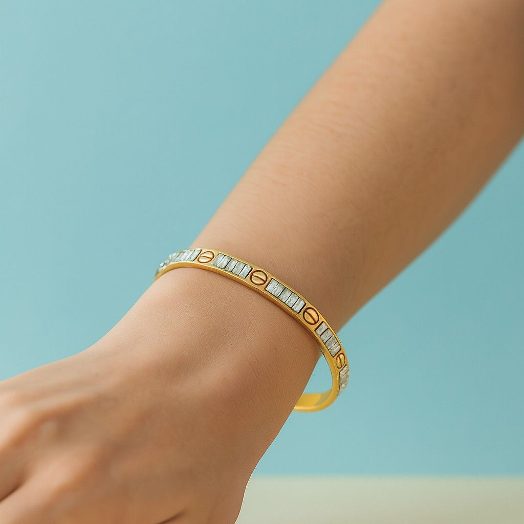 Elegant gold-tone bracelet worn on wrist with screw design and stones