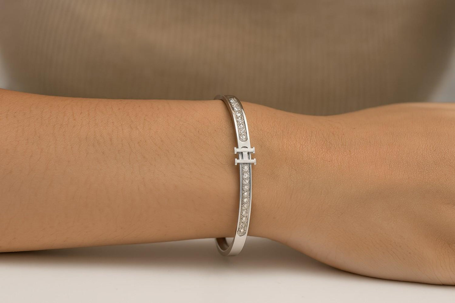 Silver-tone bracelet with 'H' initial and sparkling stones on wrist
