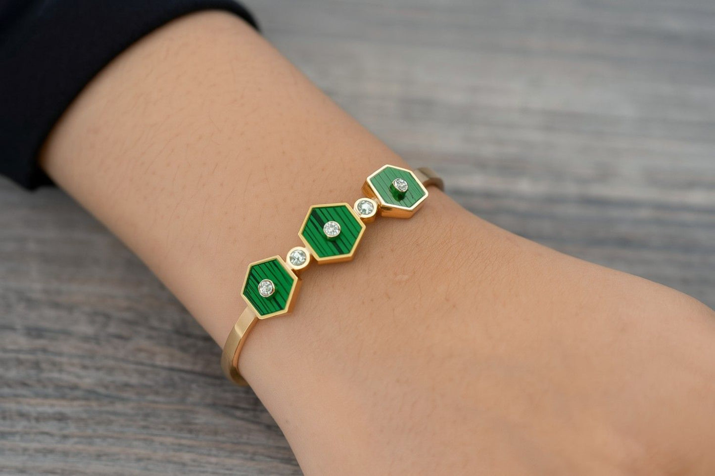 Elegant green and gold bracelet worn on wrist with hexagon motifs