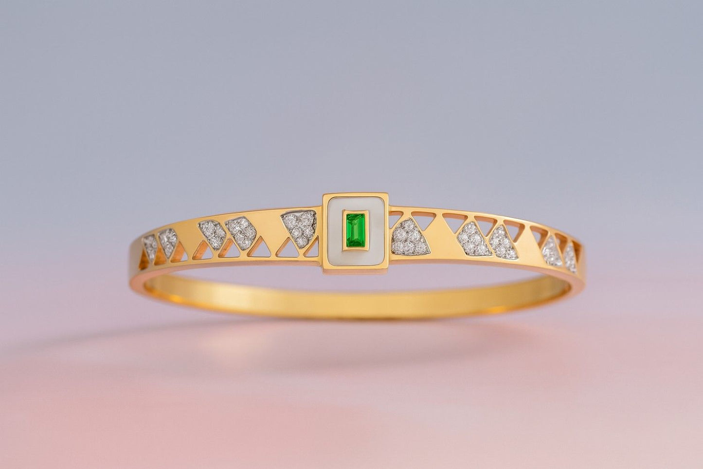 Gold-tone bracelet with geometric cut-out design and green stone centerpiece