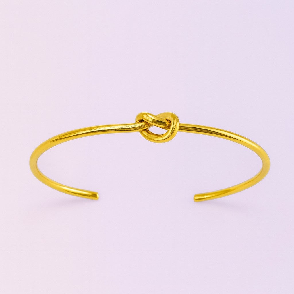Minimalist gold-tone open cuff bracelet with central knot design