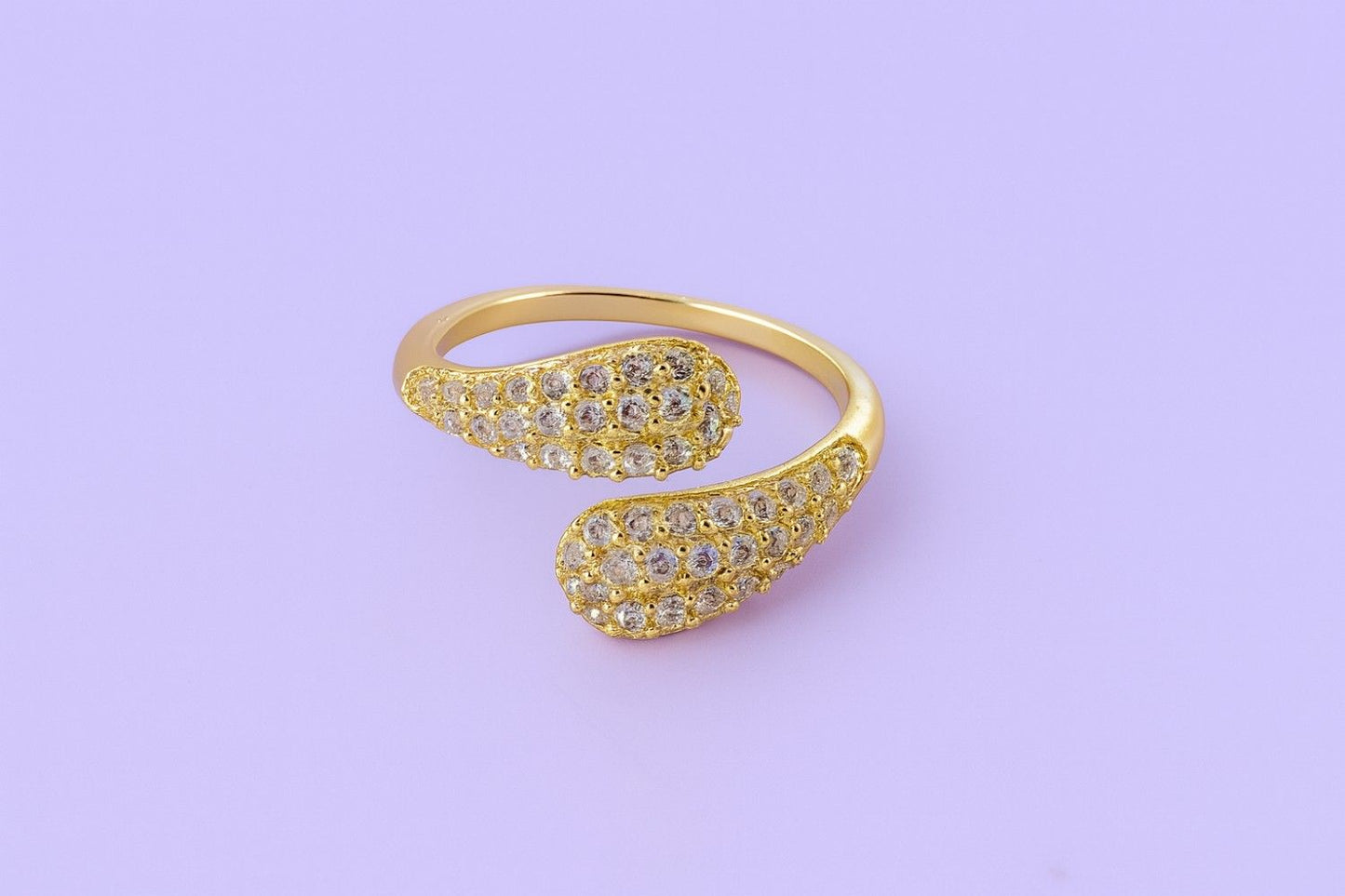 "Gold-tone teardrop crystal ring with twin ends and sparkling stones"