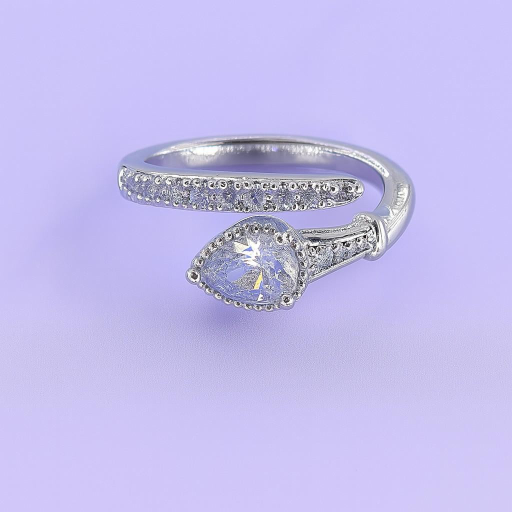 "Silver-tone teardrop stone ring with crystal band on pastel background"
