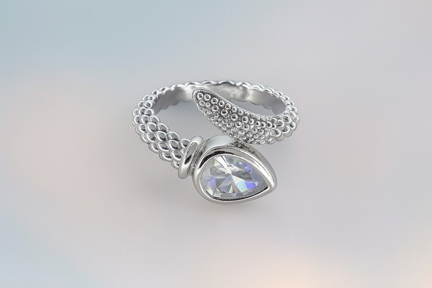 "Silver-tone textured band ring with teardrop stone and crystal accents"