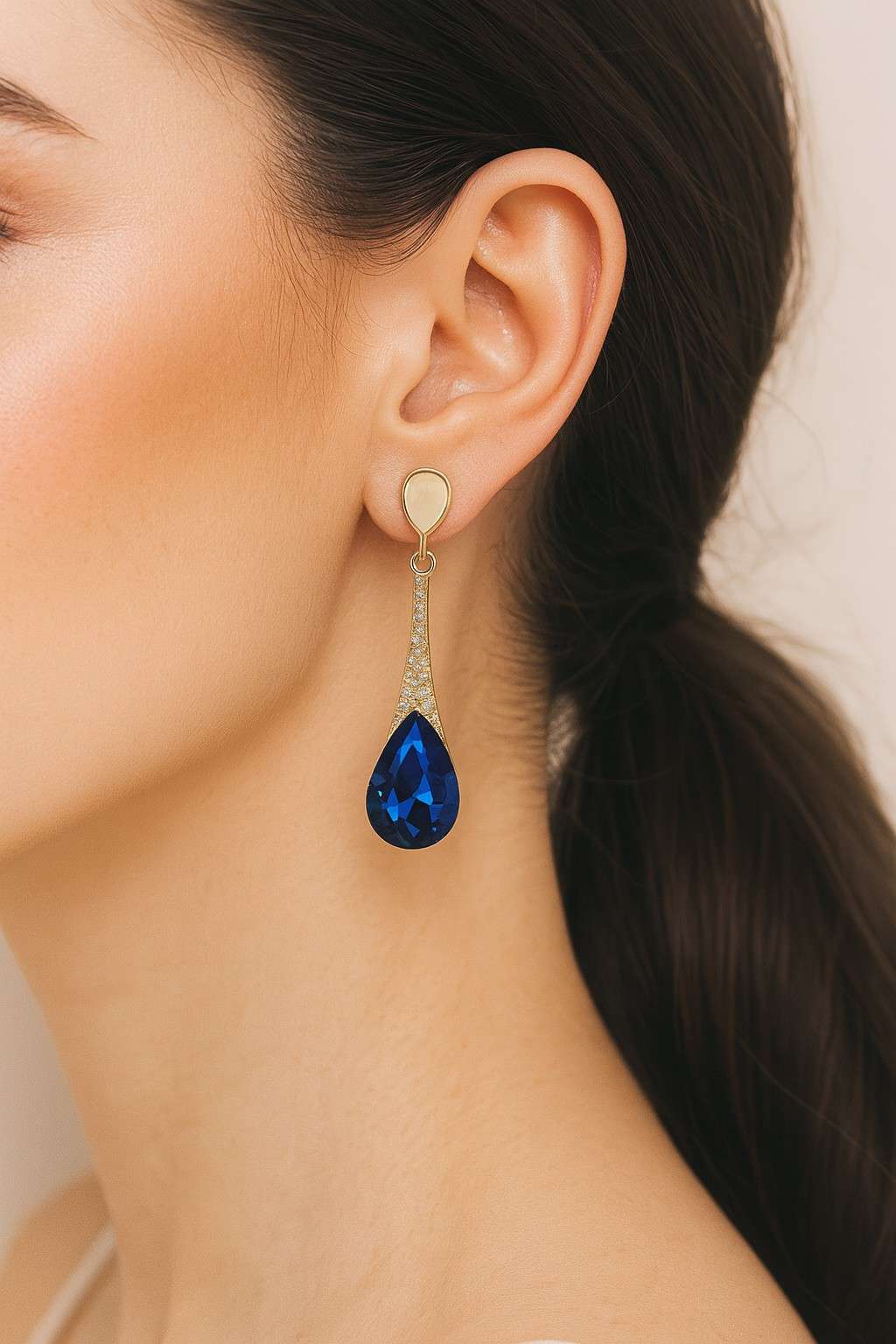 "Model wearing elegant golden finish blue crystal drop earrings"