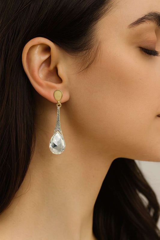 Model wearing golden finish drop earrings with clear teardrop crystal – side view