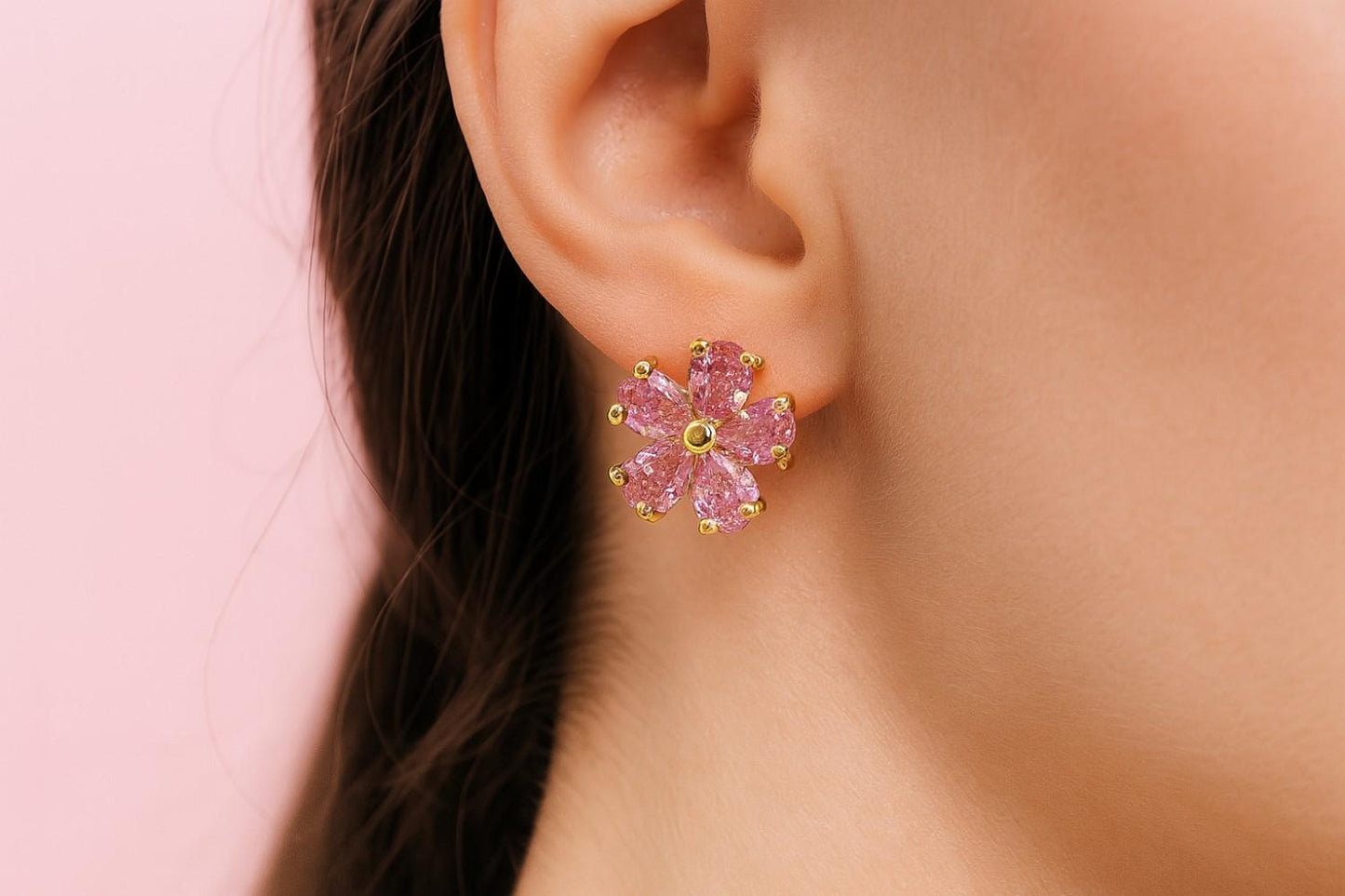 Model wearing pink floral stud earrings with gold-tone finish