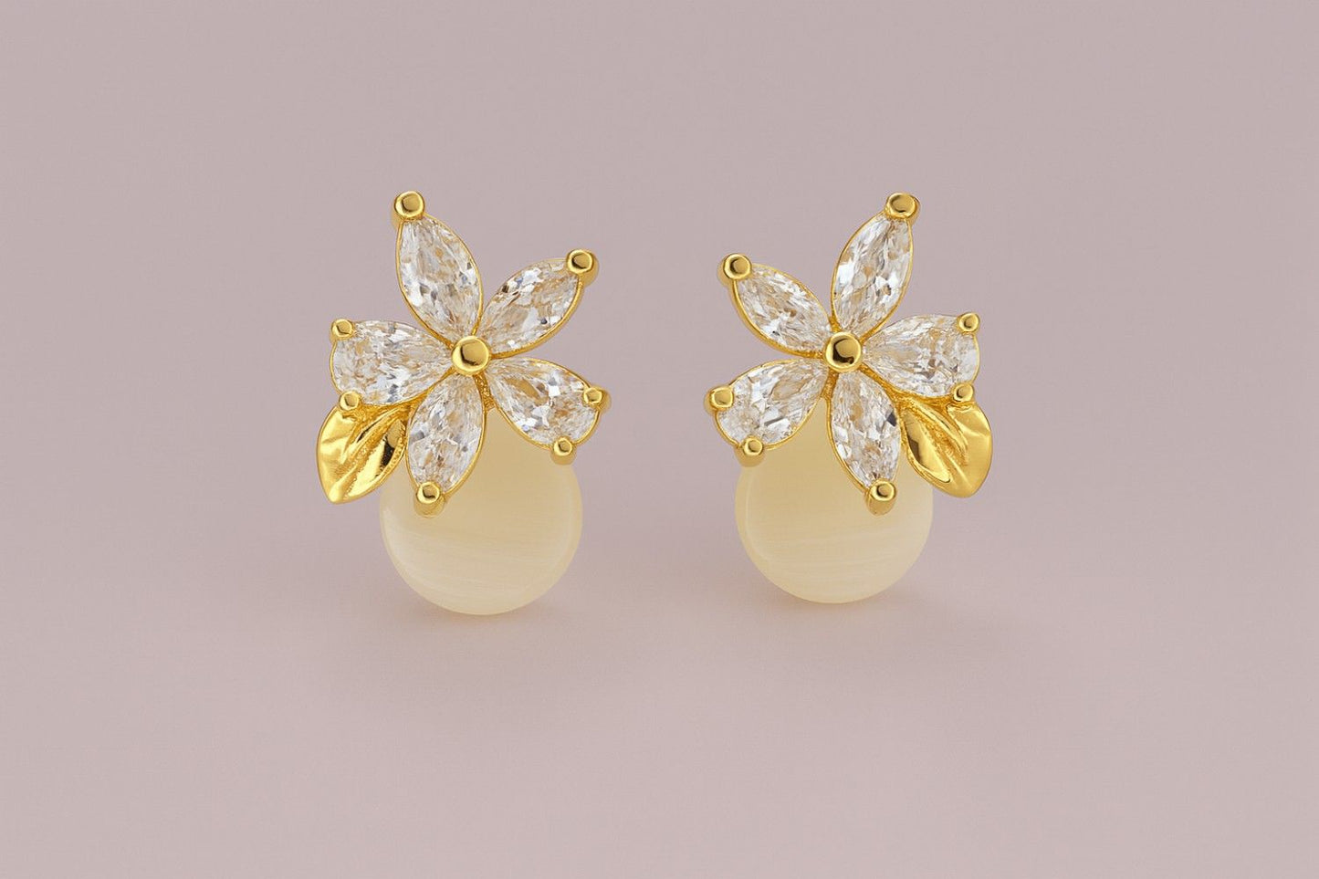 Gold-tone floral stud earrings with crystal petals and golden leaf detail on plain background