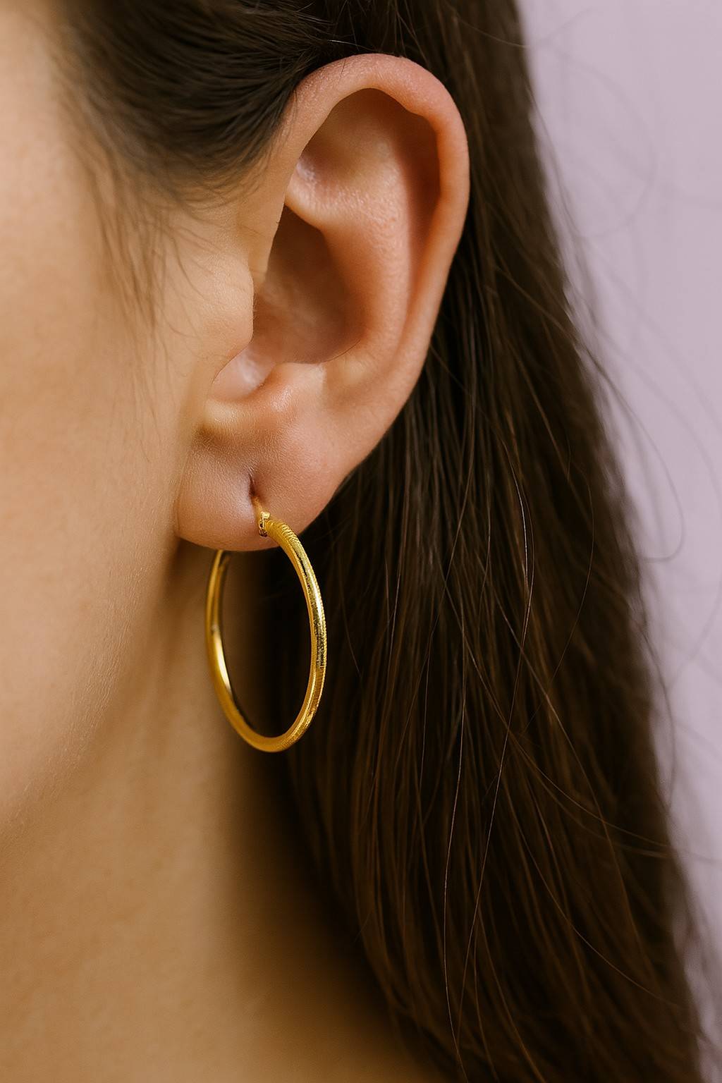 "Model wearing classic golden finish hoop earring – side view"