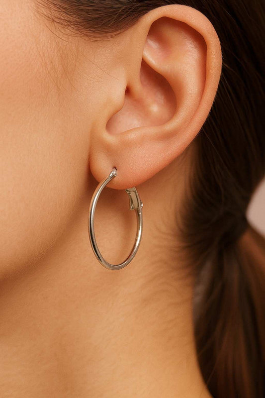 Model wearing minimalist silver-tone hoop earrings