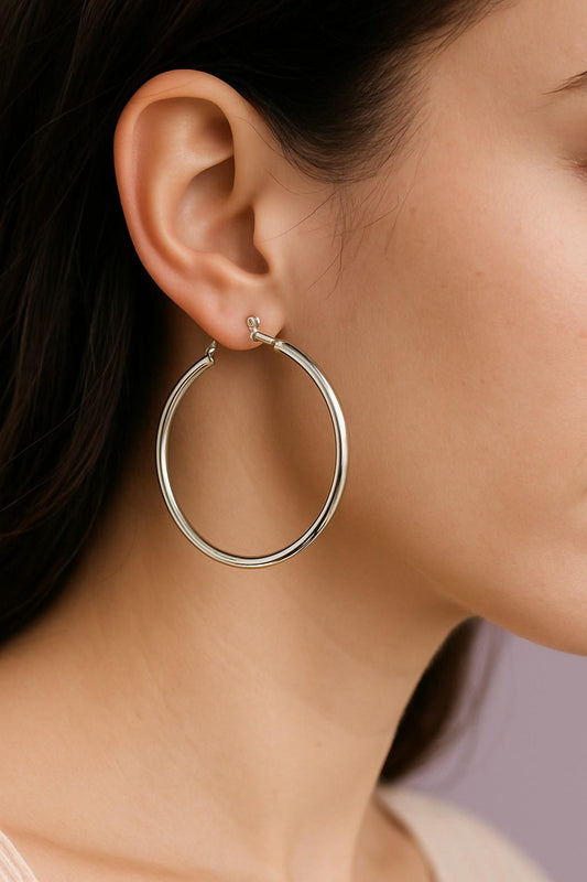 Woman wearing minimalist silver-tone large hoop earrings