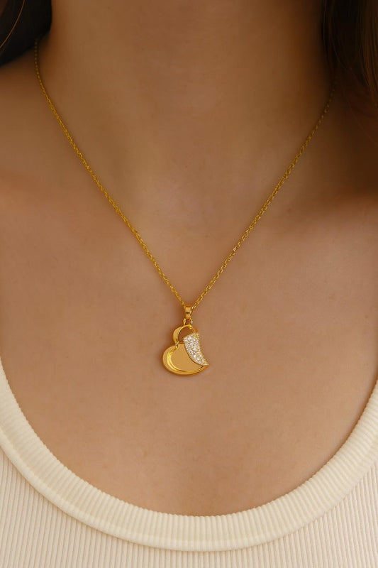 Elegant gold-tone heart pendant necklace with crystals worn on neck – model view