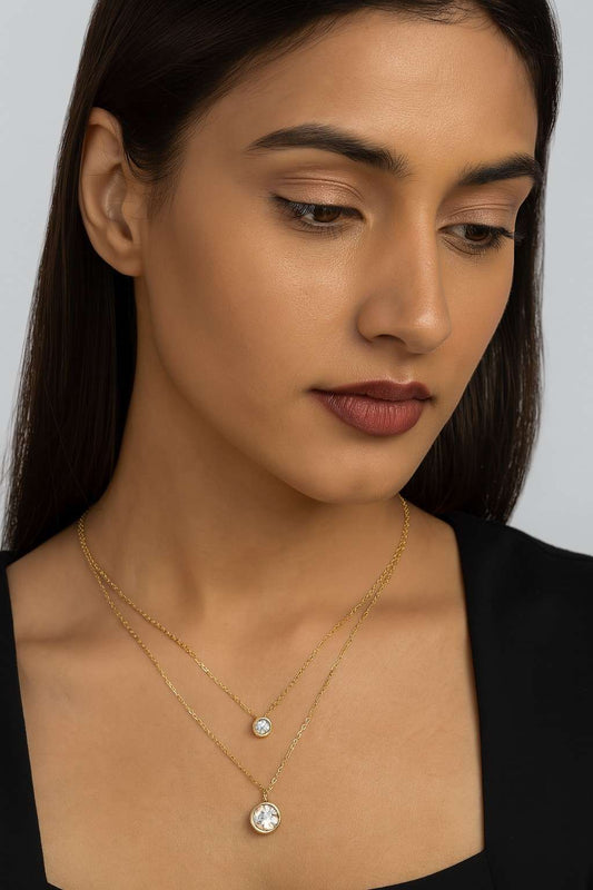 Model wearing elegant double layer gold-tone necklace with round crystal charms