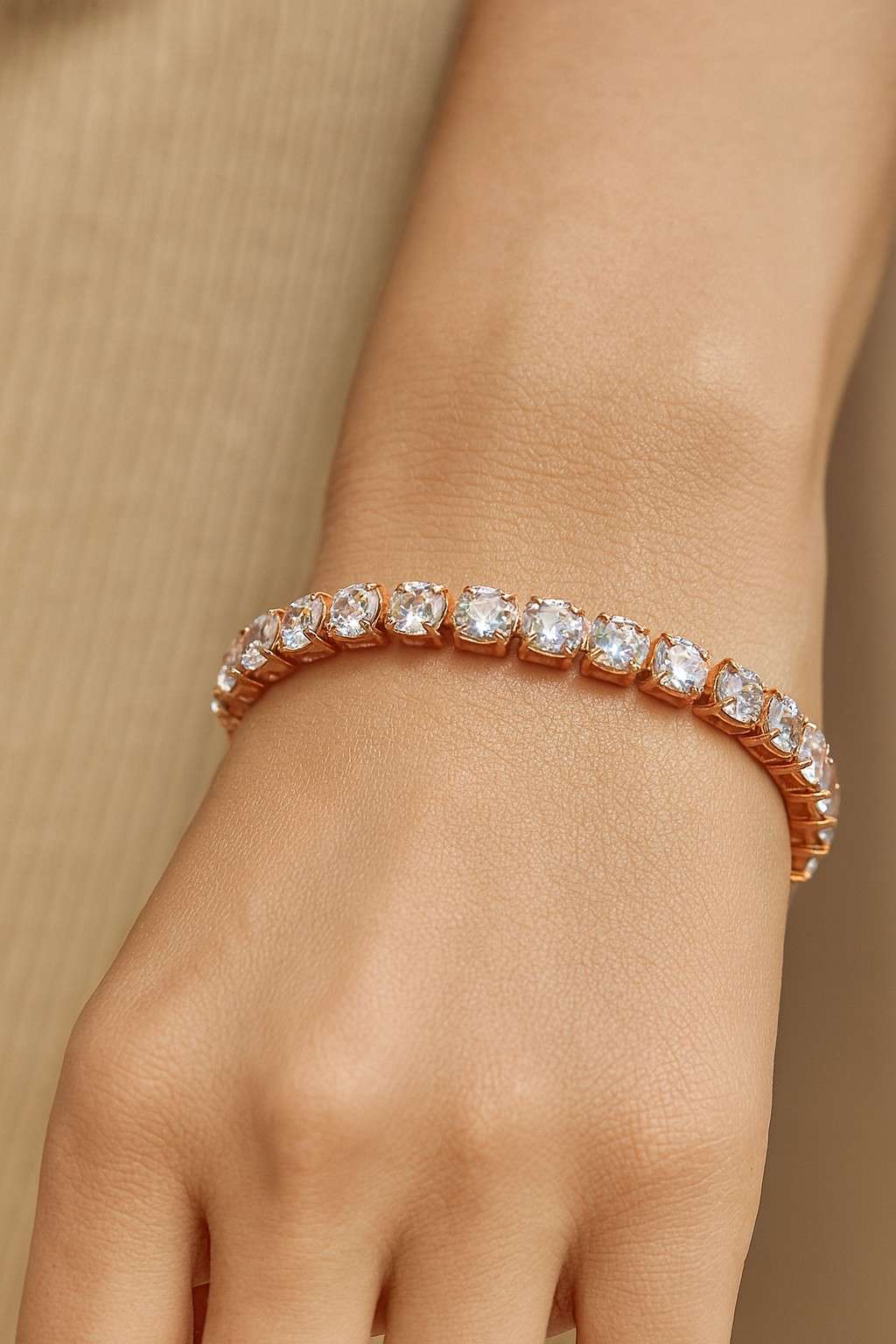 Elegant cushion-cut crystal tennis bracelet worn on wrist with rose gold-tone finish