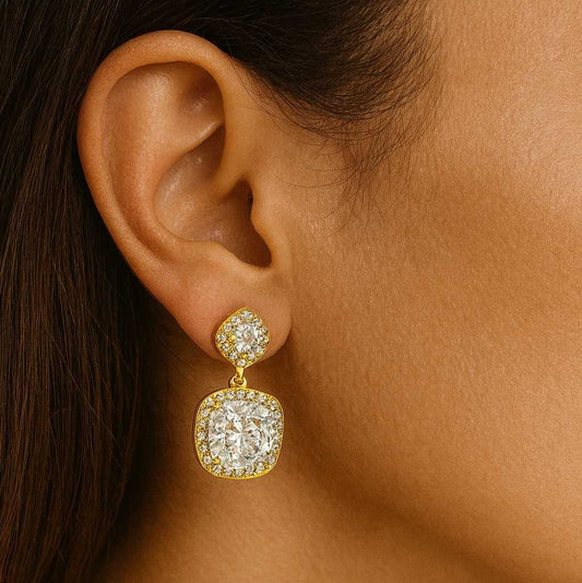 Model wearing gold-tone cushion cut crystal drop earrings