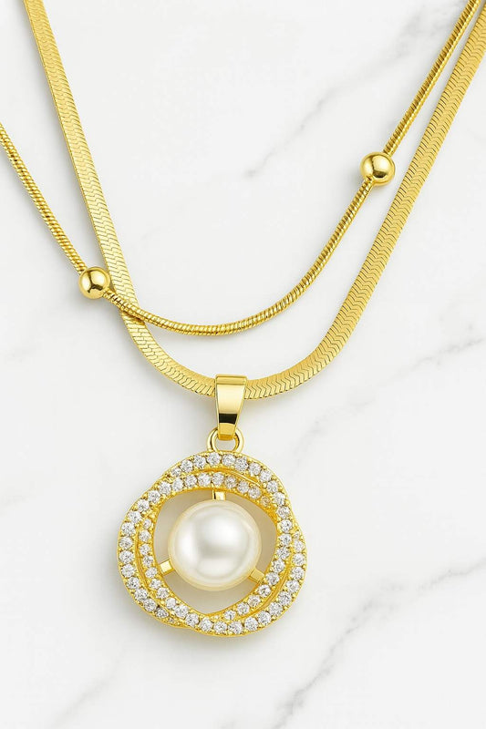 Gold-plated double-layer necklace with pearl and CZ diamond pendant on marble background - perfect for festive or party wear