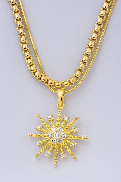 Gold-plated dual chain necklace with starburst CZ diamond pendant on soft grey background – perfect for bridal or party wear

