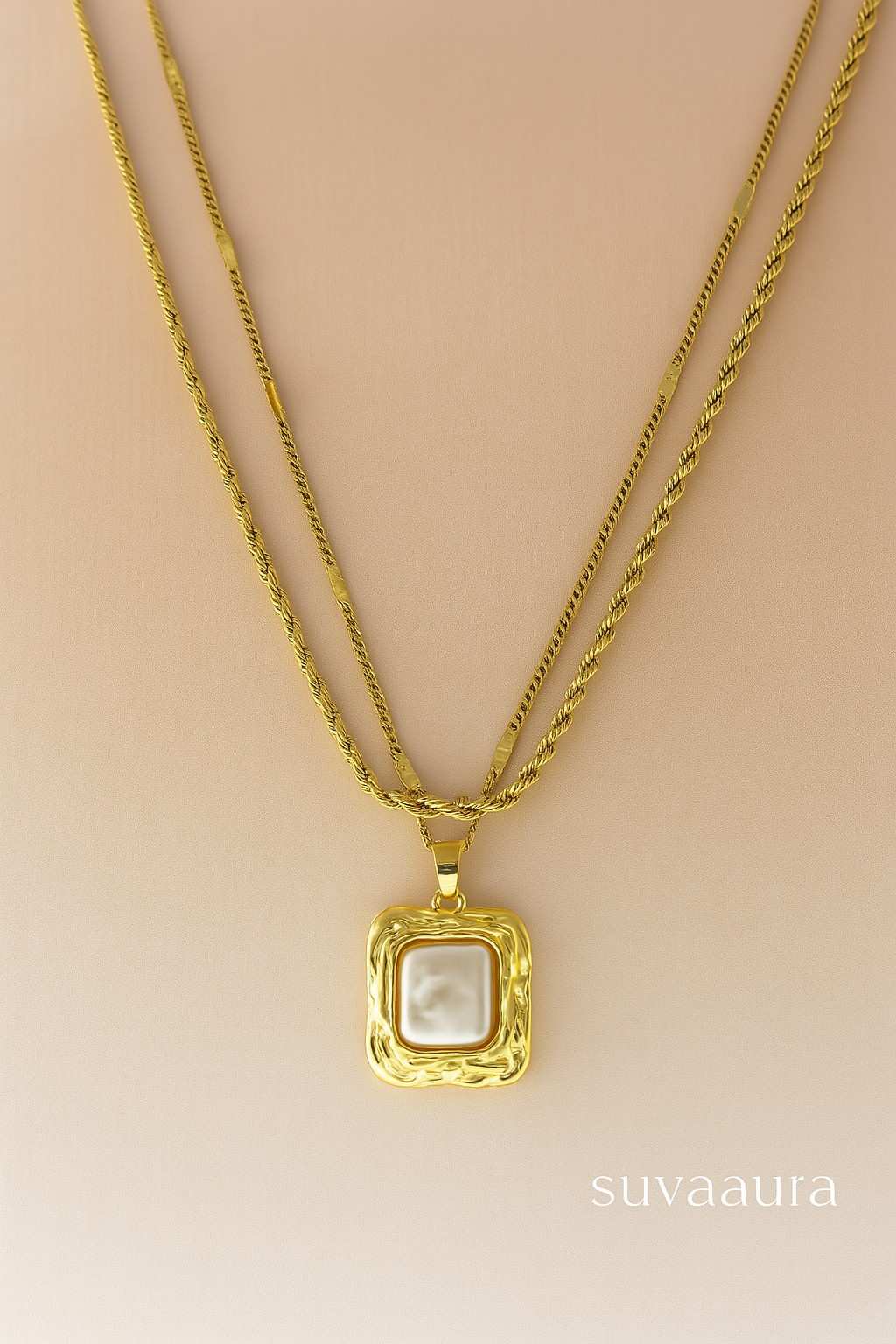 Triple-layer twisted rope gold necklace with square pearl pendant on beige background – modern Indo-western design