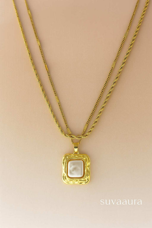 Triple-layer twisted rope gold necklace with square pearl pendant on beige background – modern Indo-western design