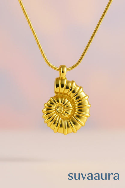 Golden spiral shell pendant necklace with snake chain on soft gradient background – artistic and bold design from Suvaaura

