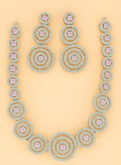 Elegant golden circular necklace set with pink stones on peach background