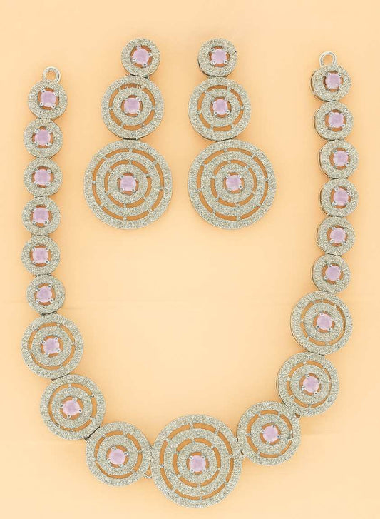 Elegant golden circular necklace set with pink stones on peach background