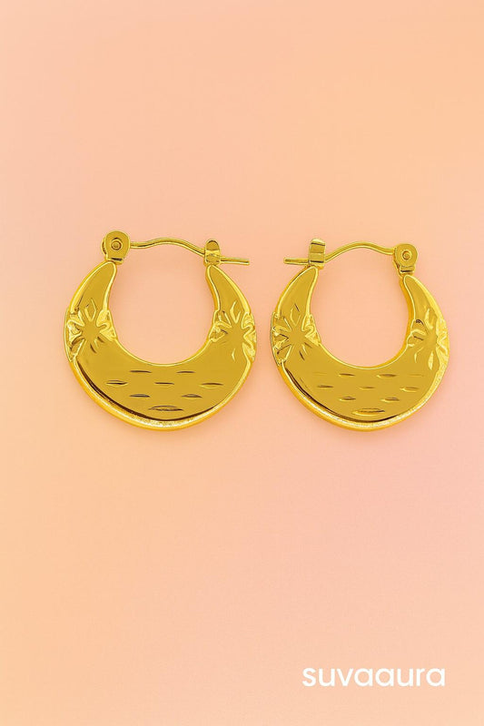Gold-plated moon-shaped hoop earrings with ethnic floral texture on peach background – festive jewellery by Suvaaura

