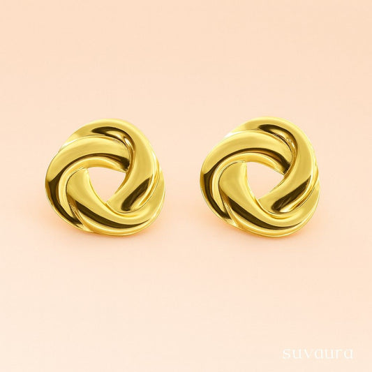 Glossy twisted knot-style round gold stud earrings on peach background – designer minimal earrings by Suvaaura


