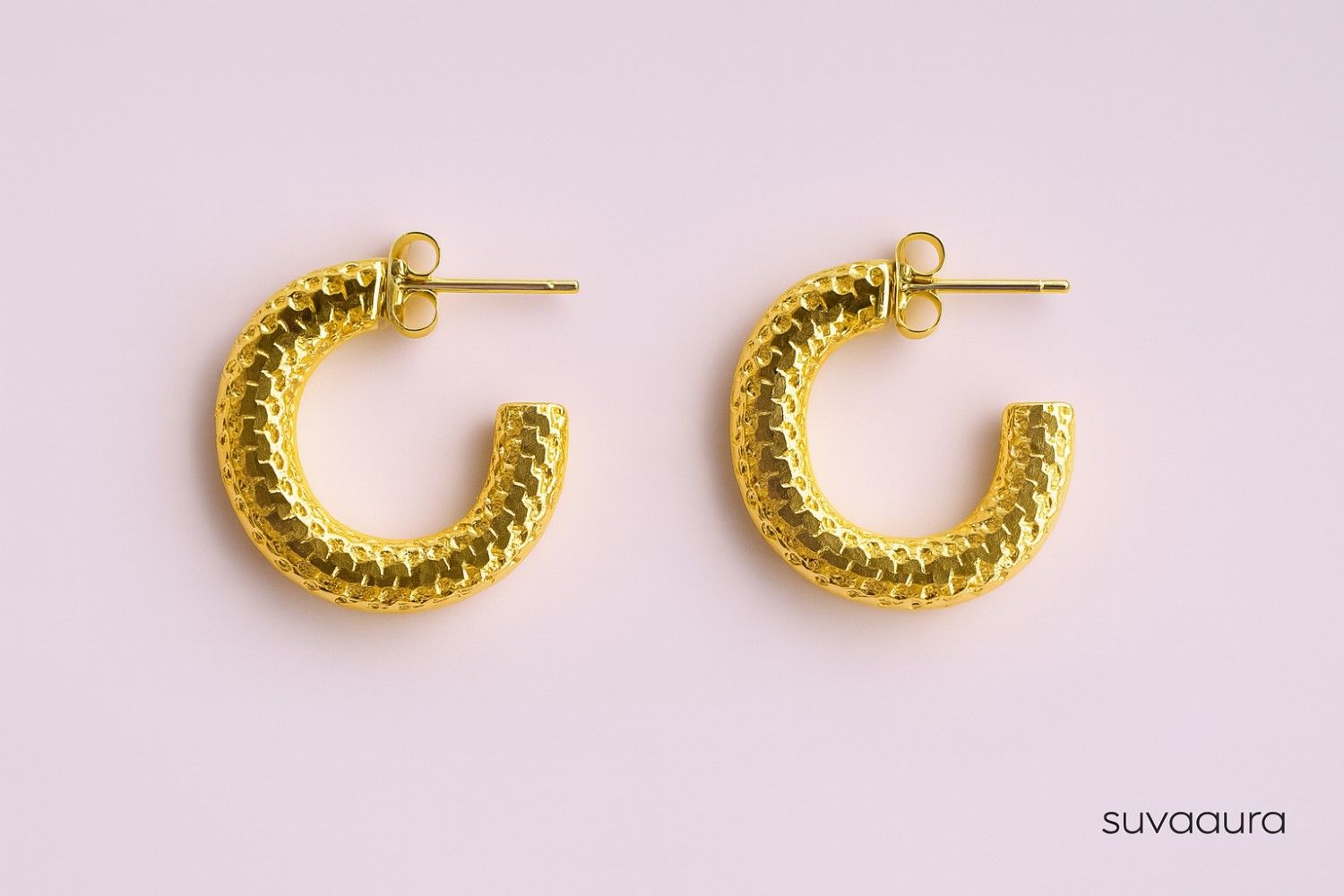 Textured gold-plated C-shaped hoop earrings on pink background – everyday style by Suvaaura