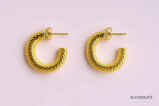 Textured gold-plated C-shaped hoop earrings on pink background – everyday style by Suvaaura