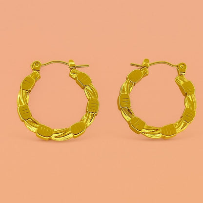 Gold hoop earrings with beaded and twisted texture on peach background – Suvaaura chunky hoop design