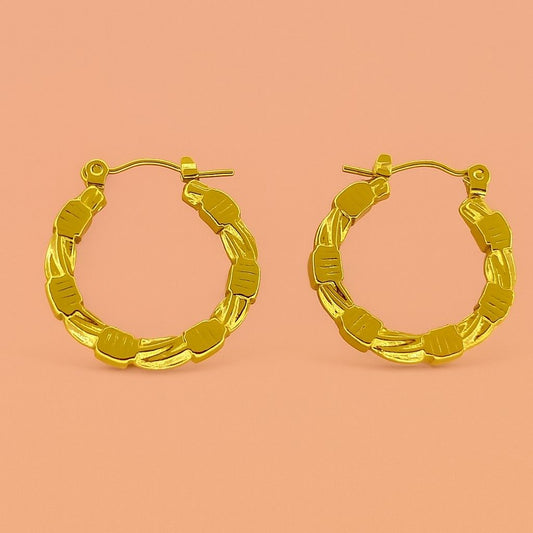 Gold hoop earrings with beaded and twisted texture on peach background – Suvaaura chunky hoop design