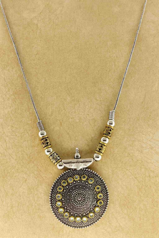 Oxidized silver round pendant necklace with antique golden beads – front view on beige background