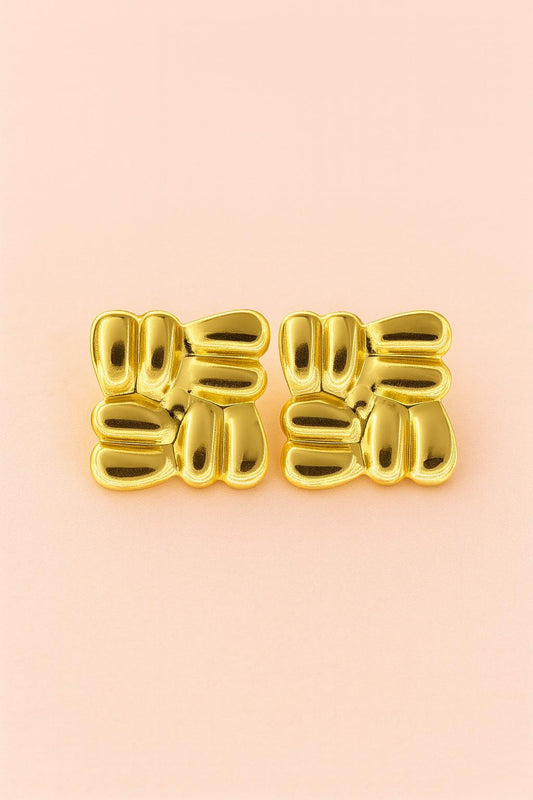 "Glossy gold imitation stud earrings on peach background – Suvaaura"


