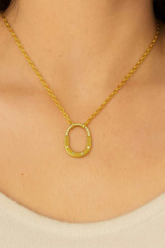 Close-up of gold-tone oval pendant on gold chain for women’s jewellery

