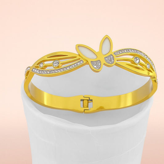Gold-colored bracelet with white enamel wings and secure clasp